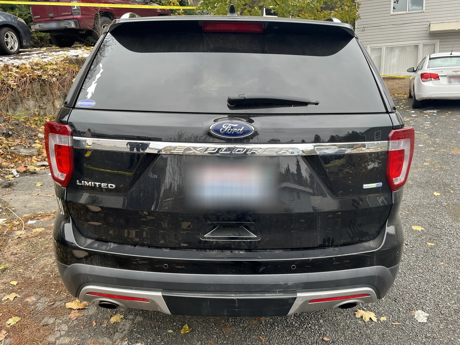 Rear of a black Ford Explorer Limited with its license plate blurred in the source image.