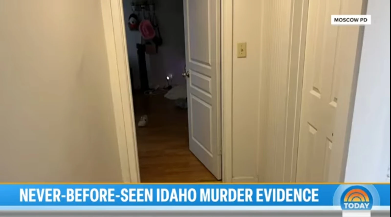 News screenshot of a hallway with an open white door, wood flooring and a caption banner.