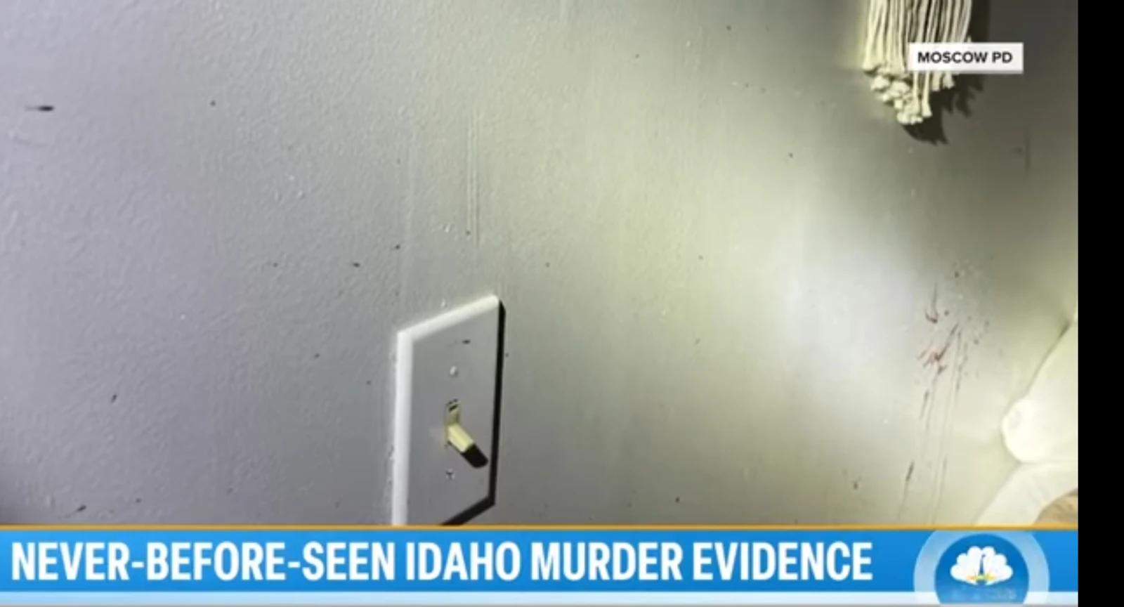 News screenshot of a wall with a light switch, small dark marks and reddish streaks.