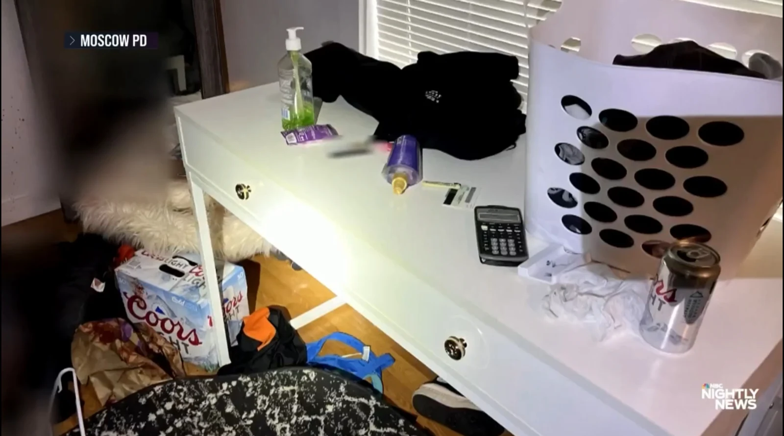 News image of a white desk holding a laundry basket, clothing, bottles and a calculator, with a beverage carton below.