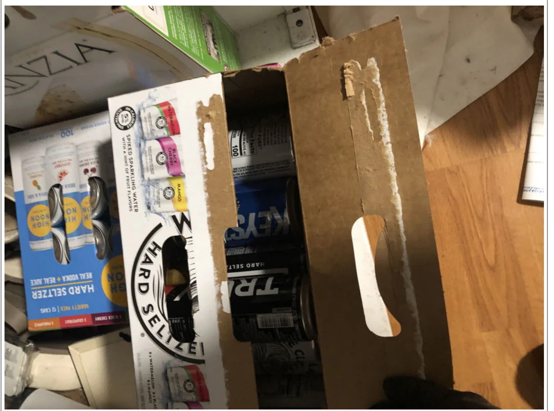 Open cardboard beverage cartons holding assorted cans, viewed from above.