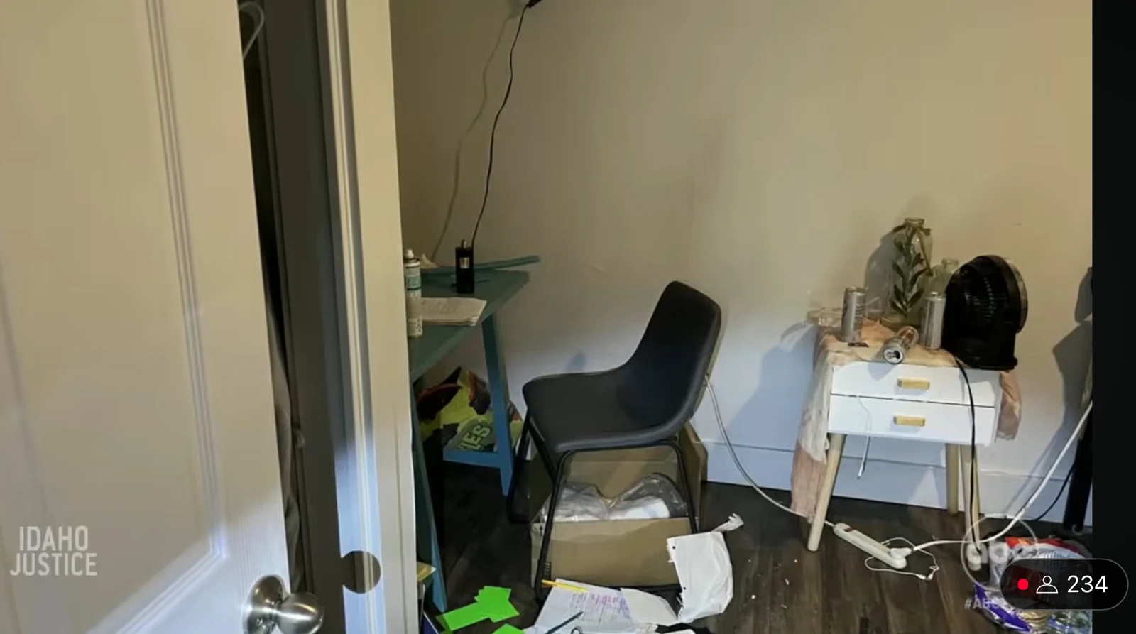 News screenshot of a small room with a chair, desk, bedside table, hanging cable and papers on the floor.