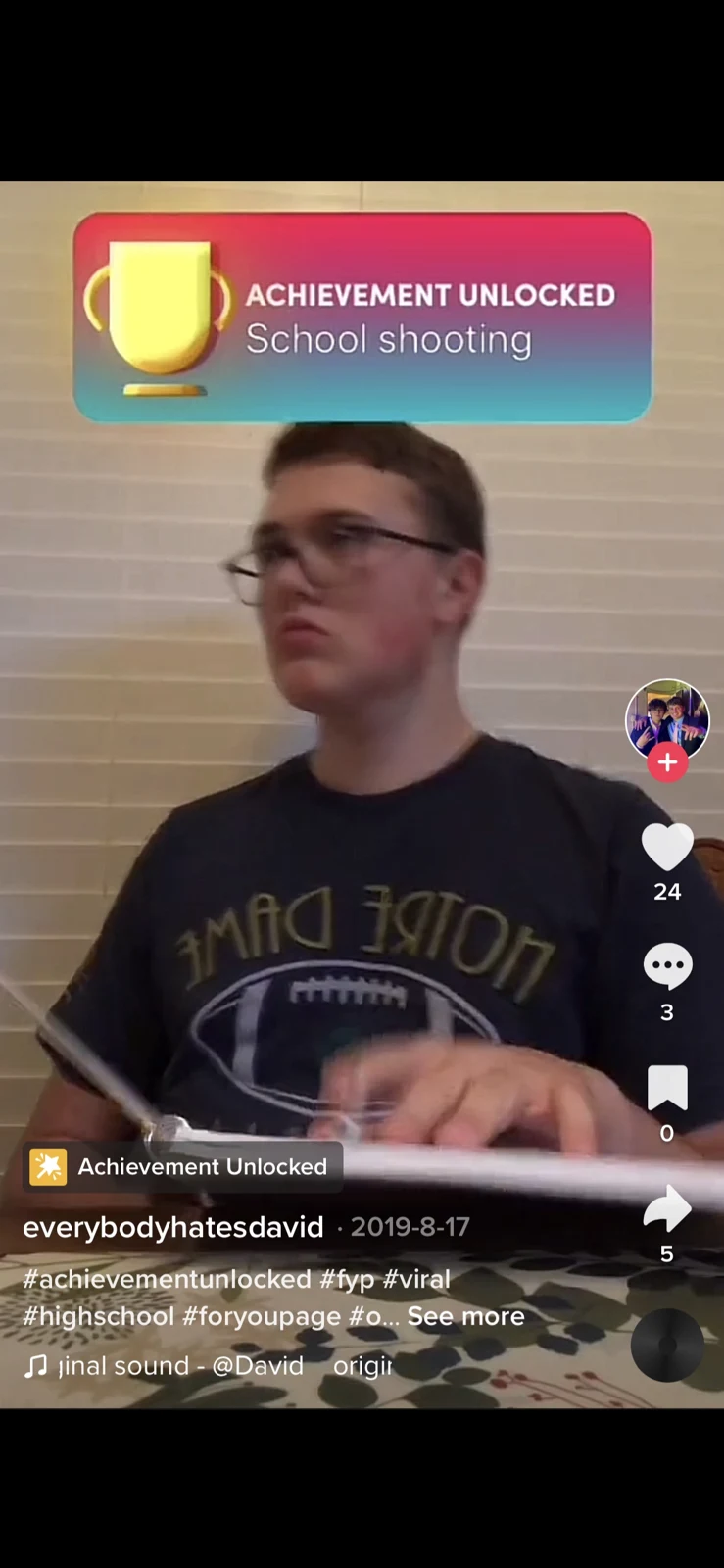 Short-video screenshot showing a person in glasses at a table beneath a trophy-style overlay with a school-shooting caption.