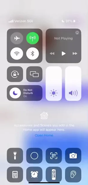 Phone control-center screenshot showing connectivity buttons, brightness and volume sliders, and utility icons.