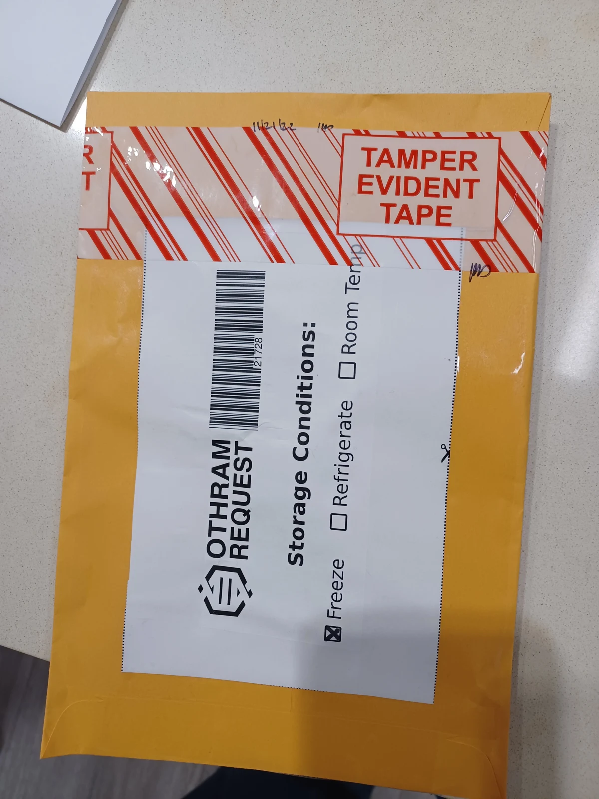Yellow padded envelope sealed with tamper-evident tape and an Othram Request storage-conditions label with Freeze checked.
