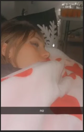Social-media photograph of a person resting their head on a patterned pillow or blanket, with the caption no.