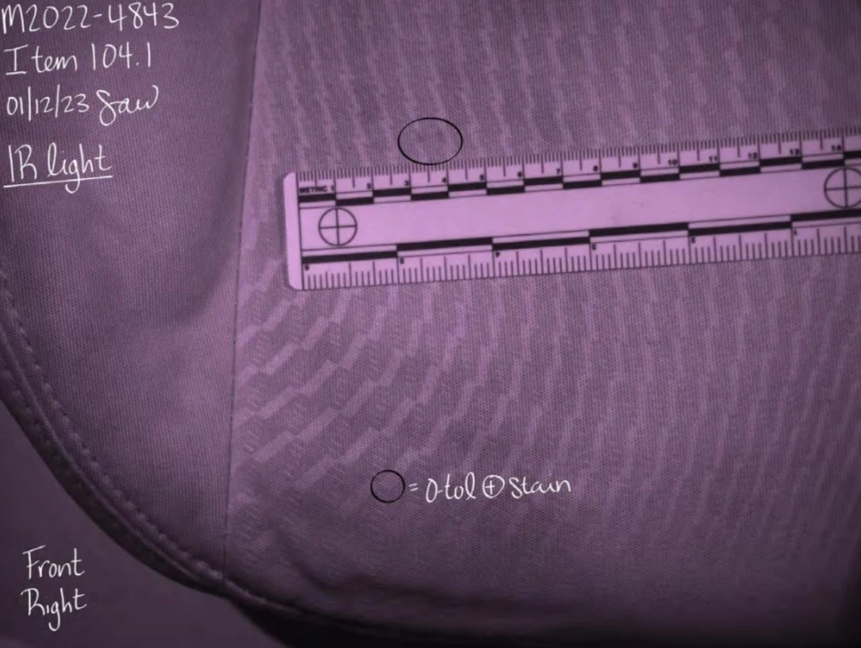 Close view of dark patterned seat upholstery under purple-toned light, with circled areas and a measurement scale.