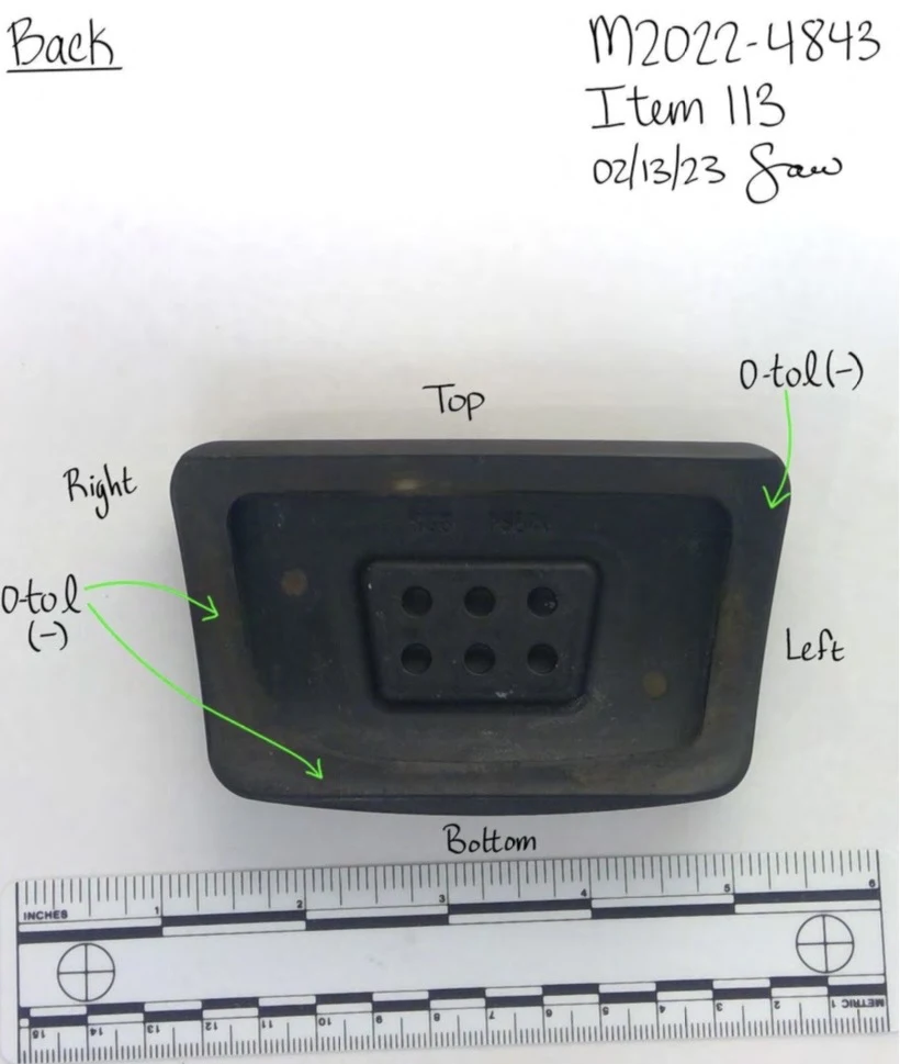 Back of a rectangular pedal pad with a central recessed area and six circular holes, above a measurement scale.