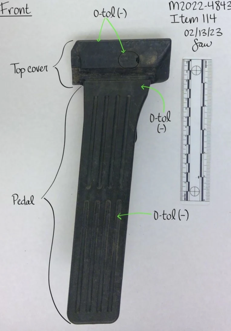 Long black ribbed vehicle pedal and top cover beside a measurement scale, with handwritten labels and green arrows.