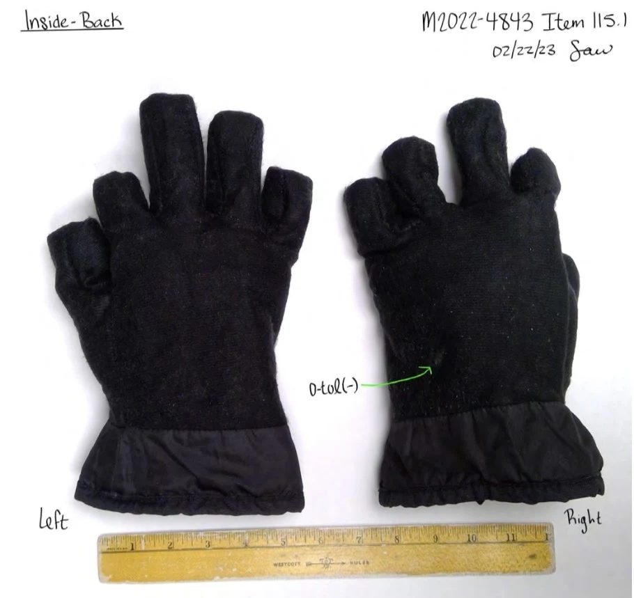 Backs of two black glove linings turned inside out, with fabric cuffs and a ruler below.