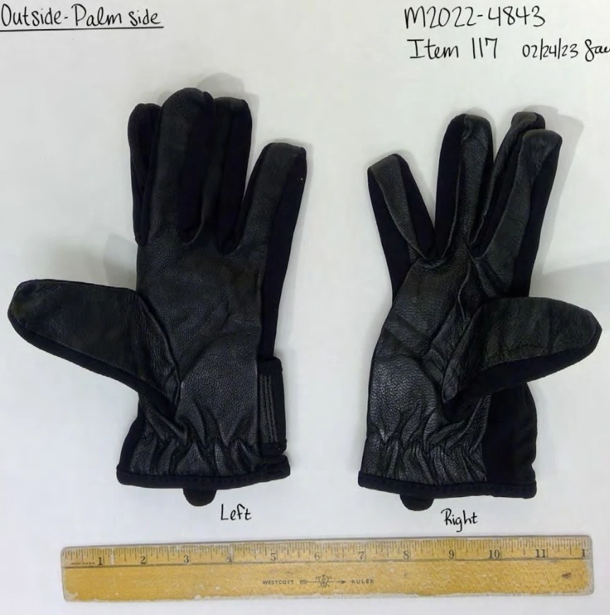 Palm sides of two dark leather-and-fabric gloves with gathered wrists, laid out beside a ruler.