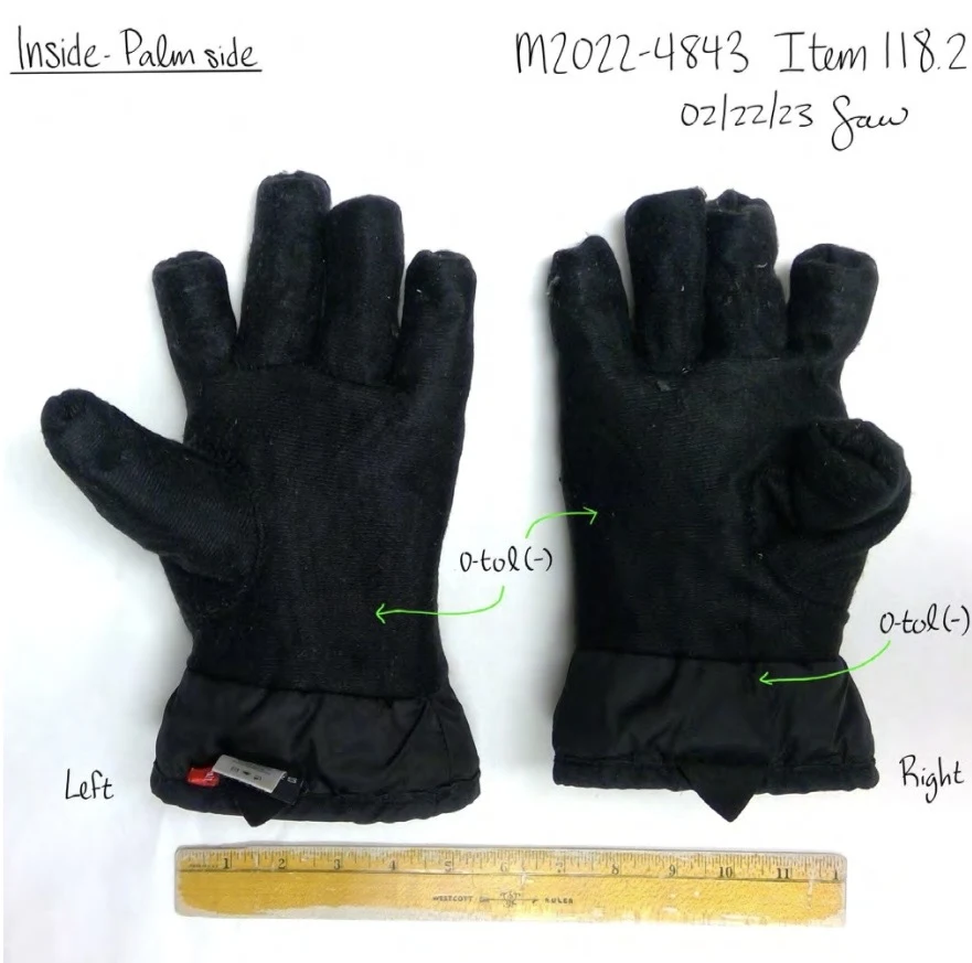 Inside palm surfaces of black glove linings with short finger sections, turned inside out and photographed beside a ruler.