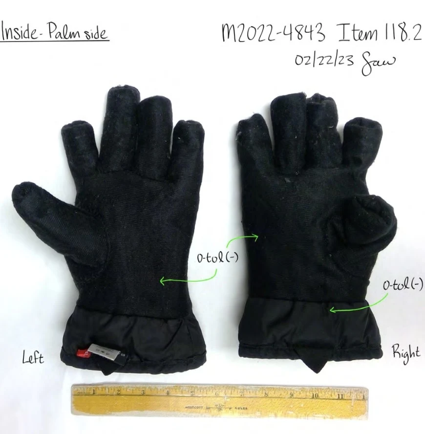 Alternate annotated photograph of inside palm surfaces of black glove linings, with short finger sections and a ruler.