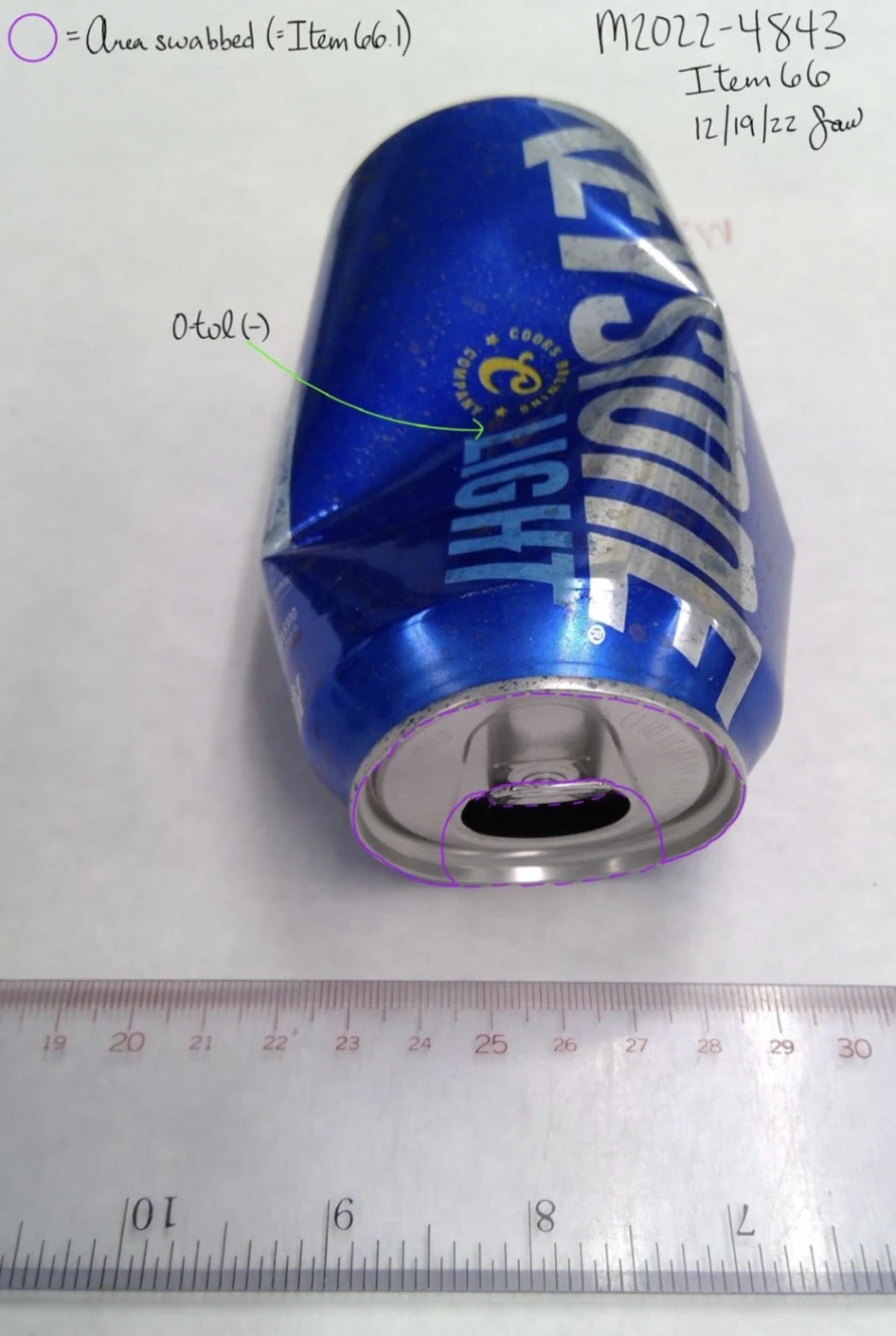 Dented blue Keystone Light can with an open pull tab, a ruler and colored swab-area markings.