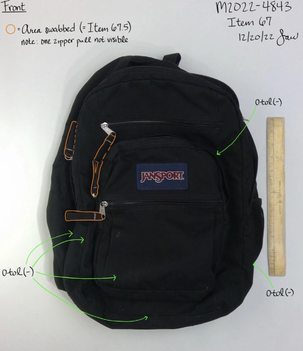 Front of a black JanSport backpack with zipper pulls outlined in orange, green arrows and a yellow ruler.