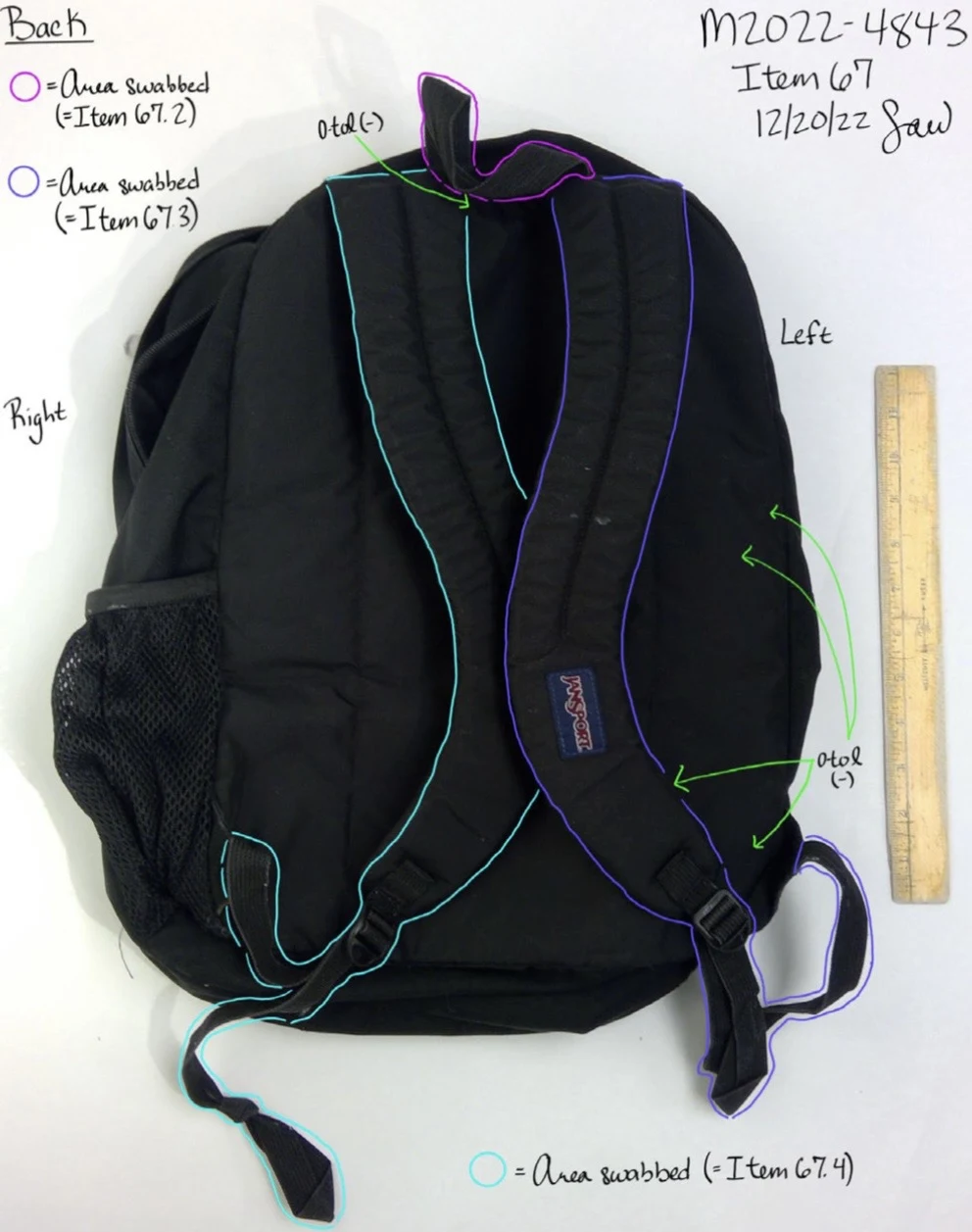Back of a black JanSport backpack with shoulder straps outlined in blue and purple, beside a yellow ruler.