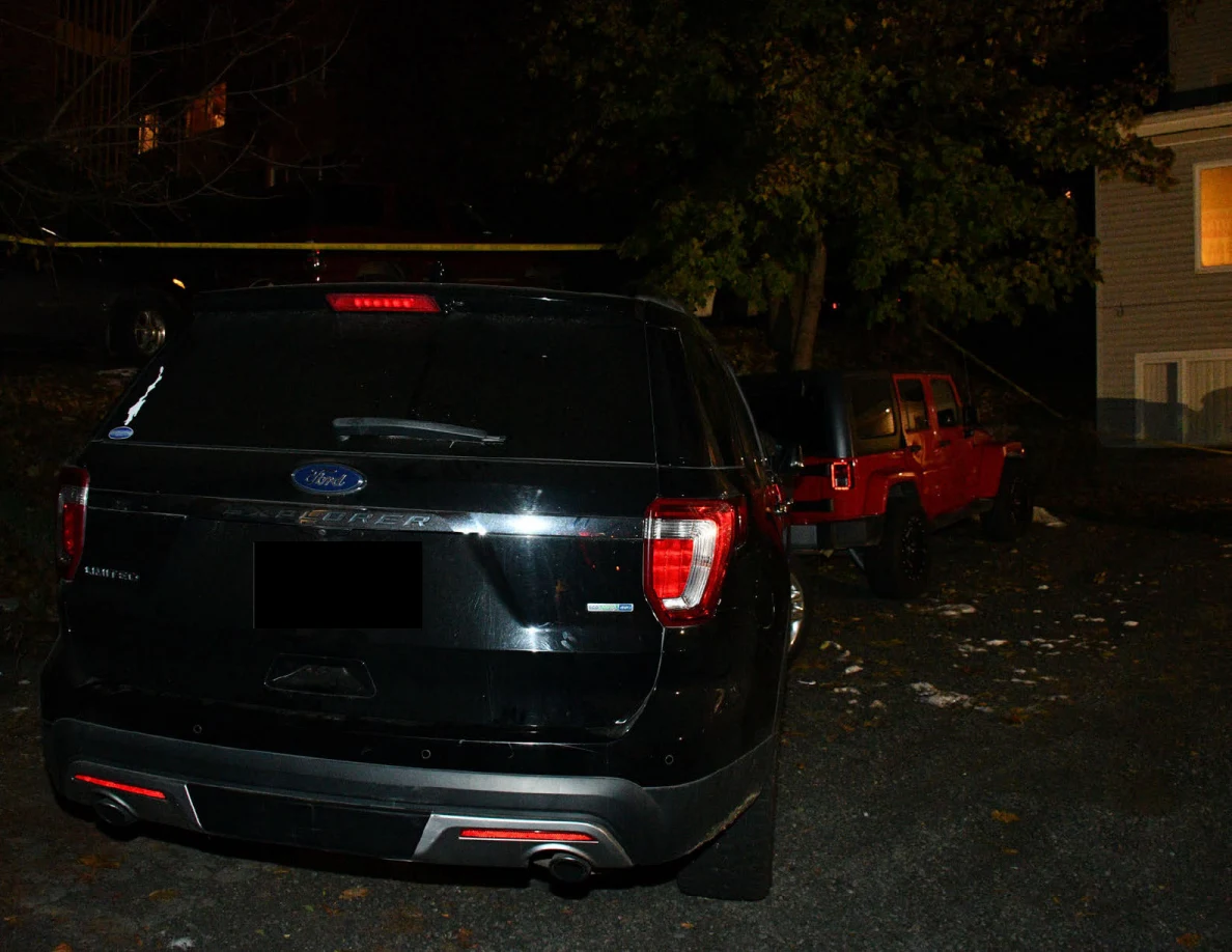 Rear of a black SUV with a red Jeep behind it.