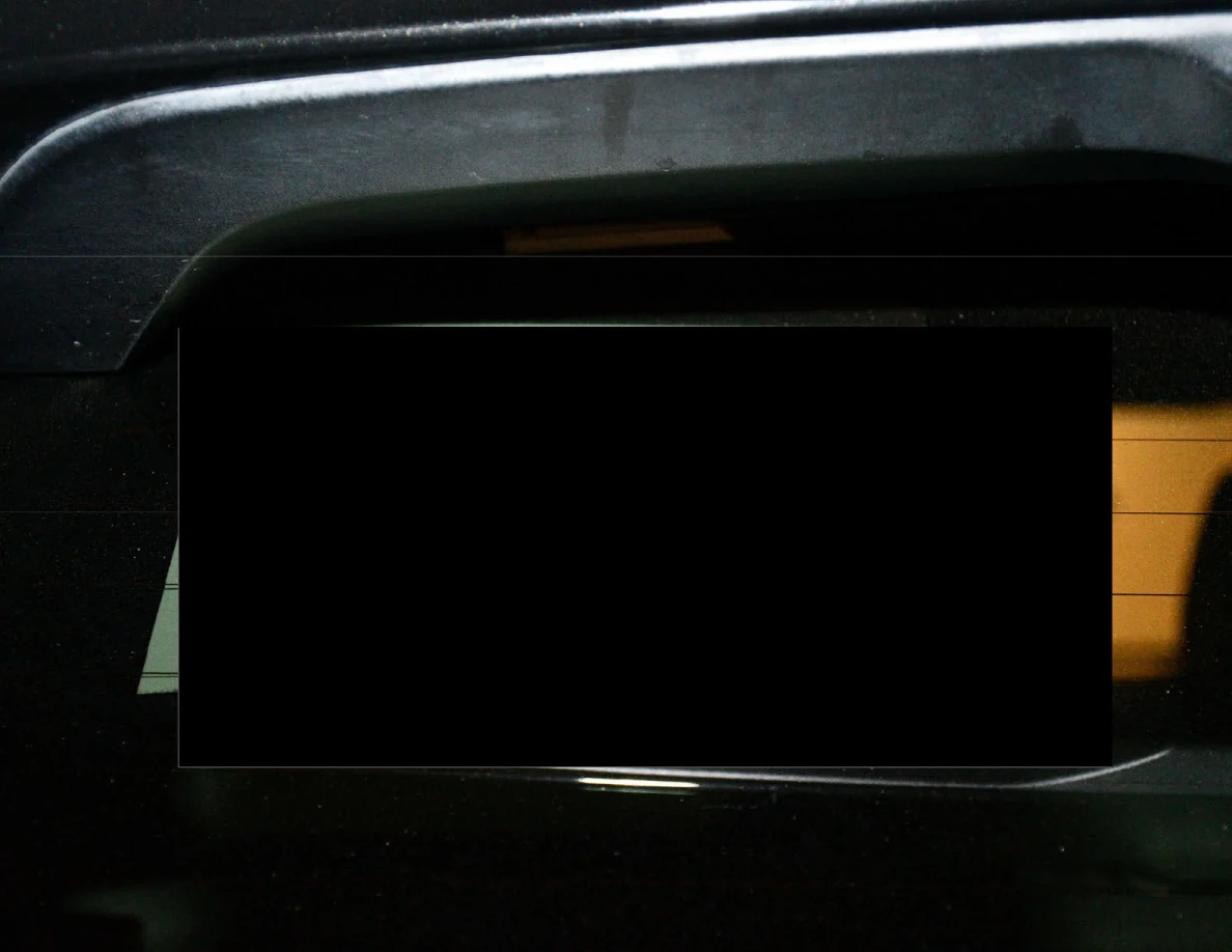 Close view of a largely redacted paper notice inside a vehicle window.
