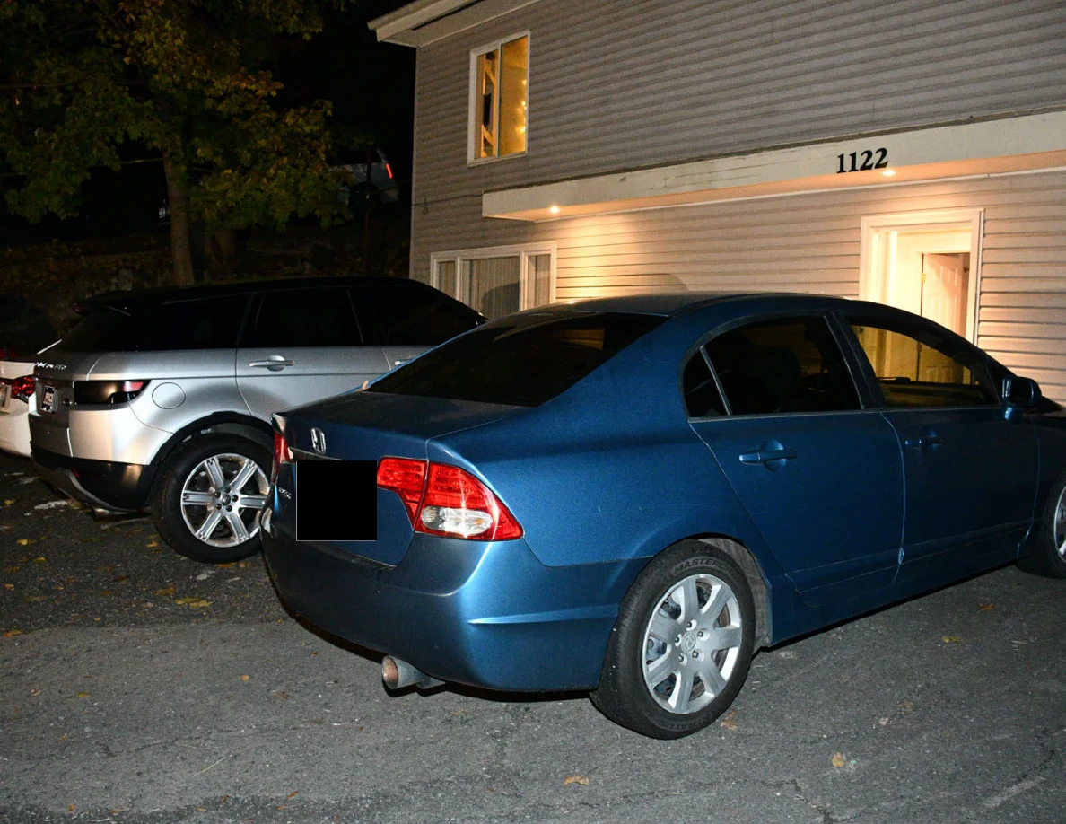 Side and rear of a blue Honda sedan with a silver SUV behind it.