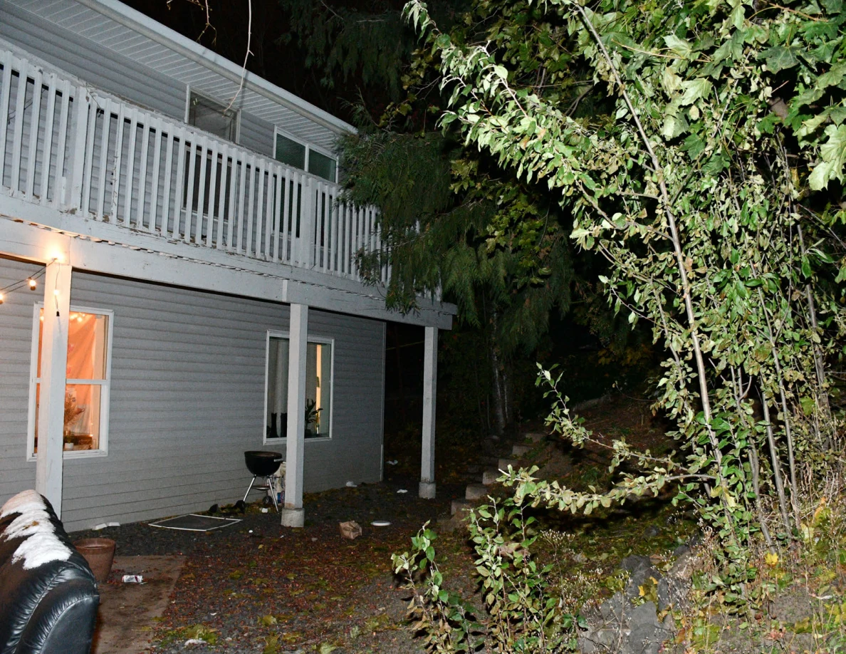 Rear balcony, patio posts, windows and a small kettle barbecue grill.