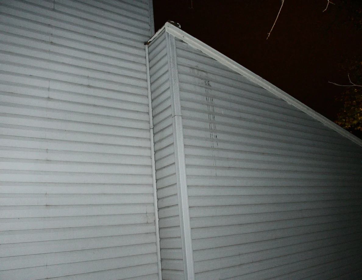 Exterior siding and roofline with visible vertical streaks.