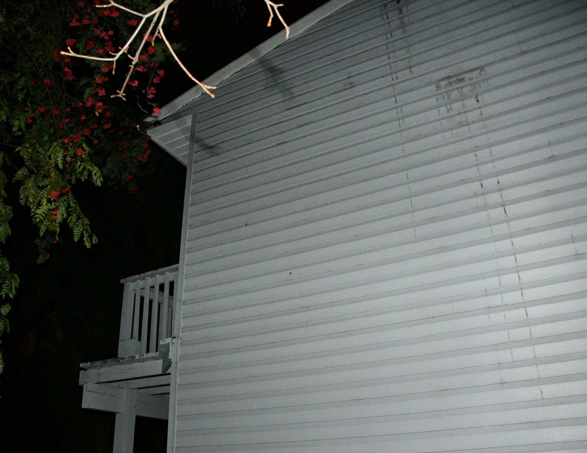 Upper exterior wall and part of a balcony railing.