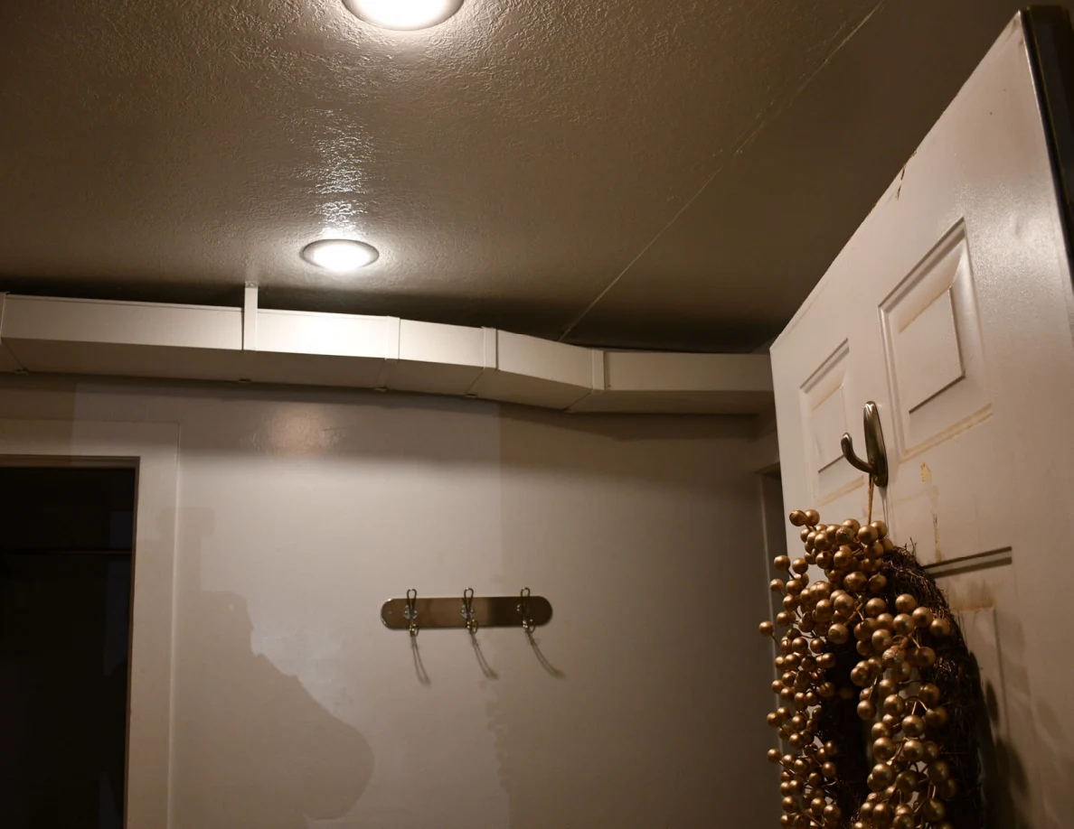 Entryway ceiling lights, exposed ductwork and door wreath.