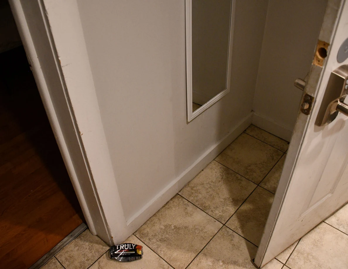 Entryway tile floor, wall mirror and open front door.