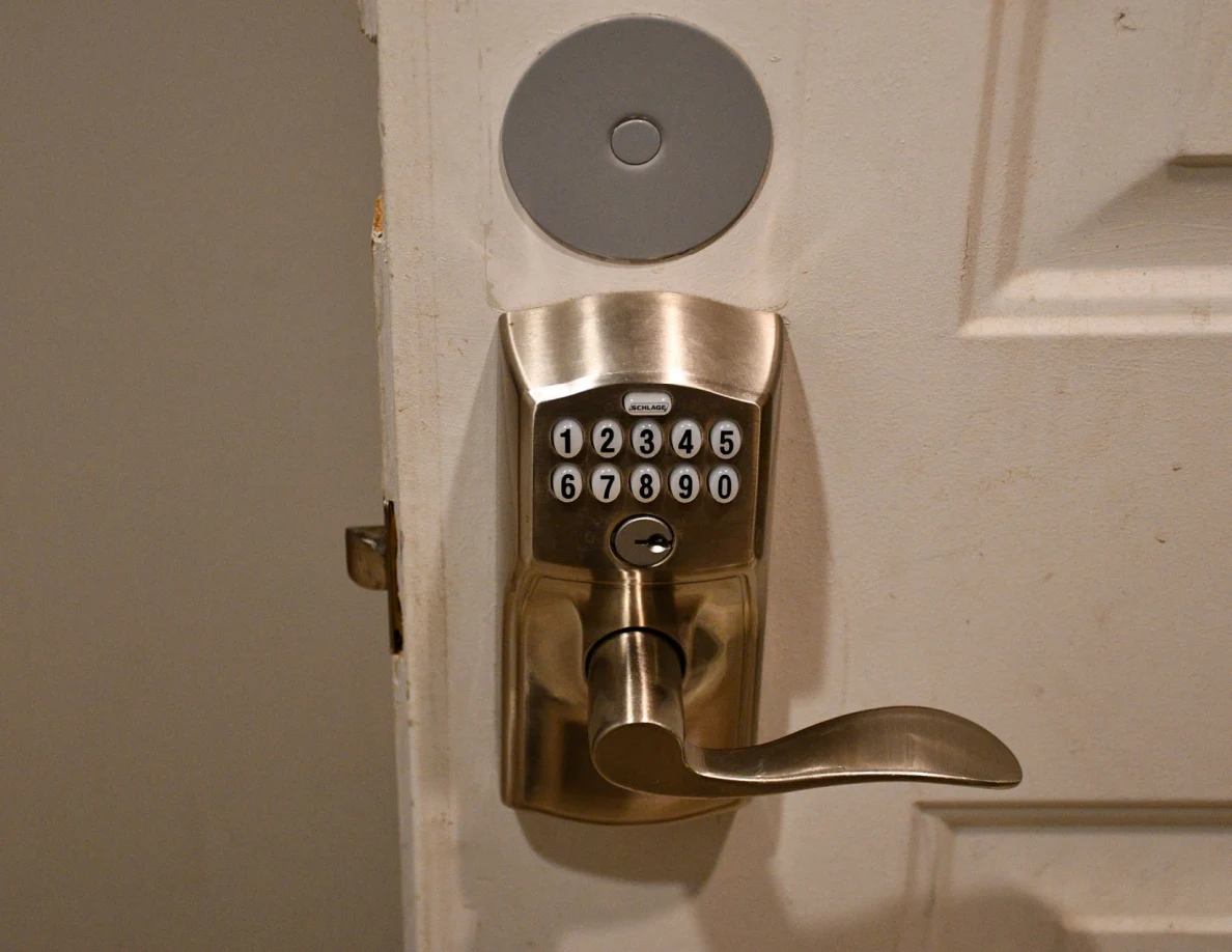 Close view of a keypad door lock and lever handle.