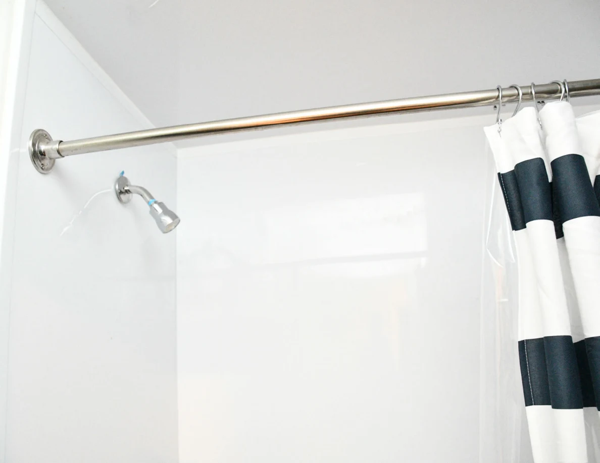 Shower head and curtain rod above a bathtub.
