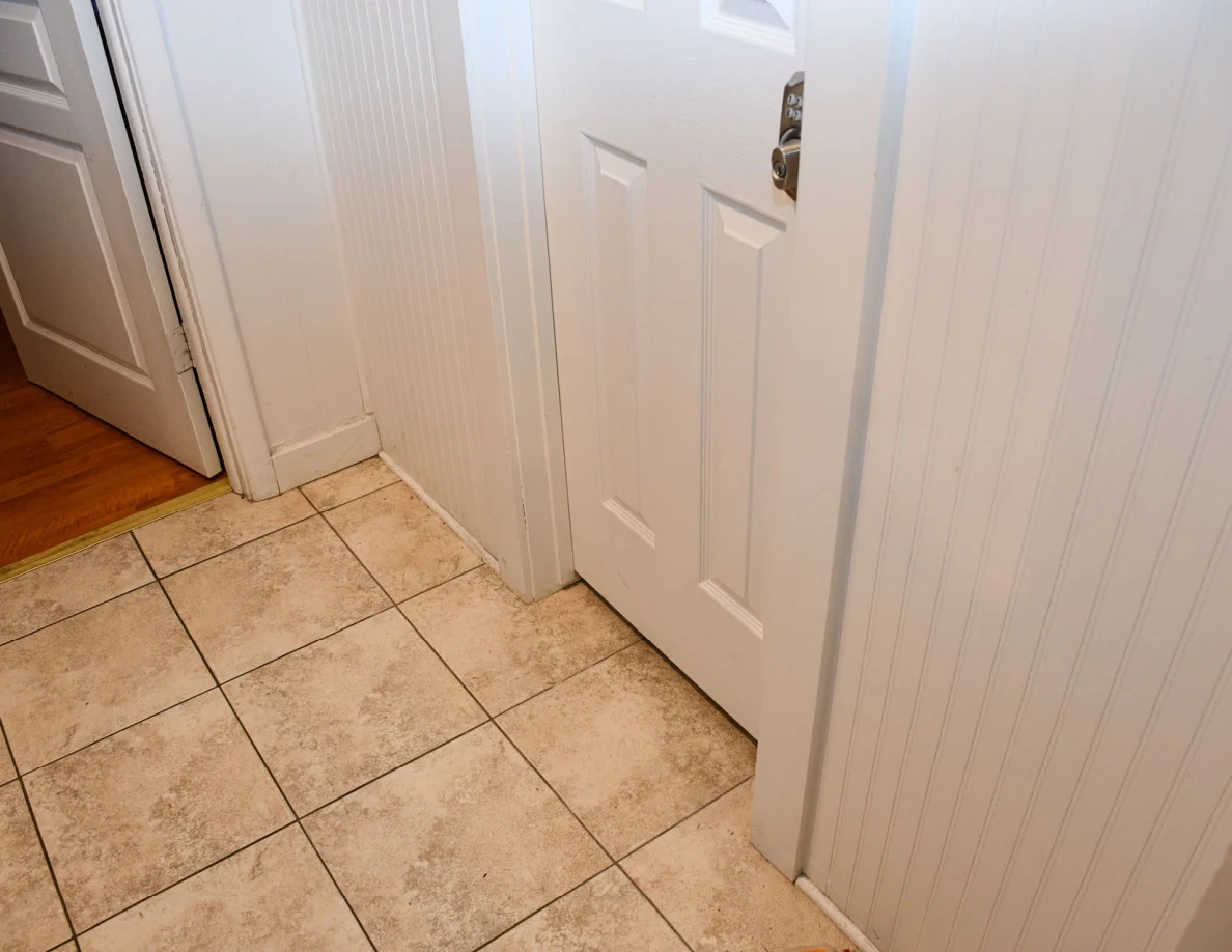 Tile floor and closed interior door with keypad lock.