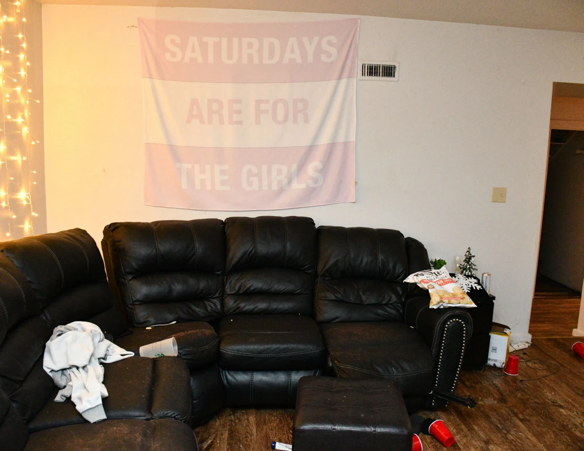 Black sectional sofa below a banner reading Saturdays Are For The Girls.