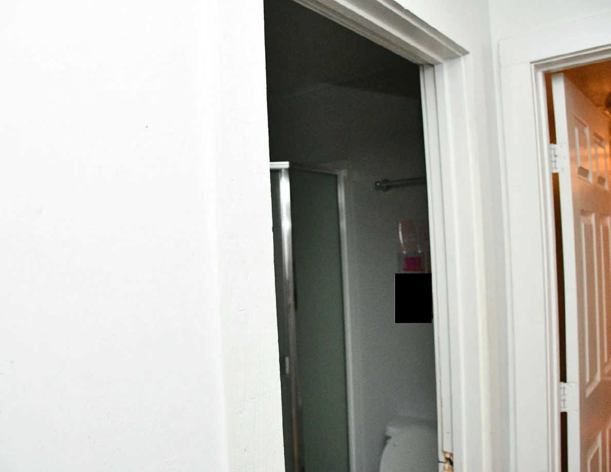 Open bathroom doorway showing part of a glass shower enclosure.