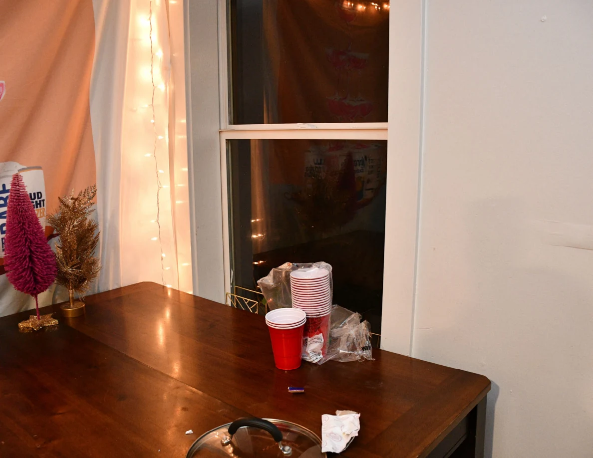 Wooden table beneath a window with stacked cups and small decorations.