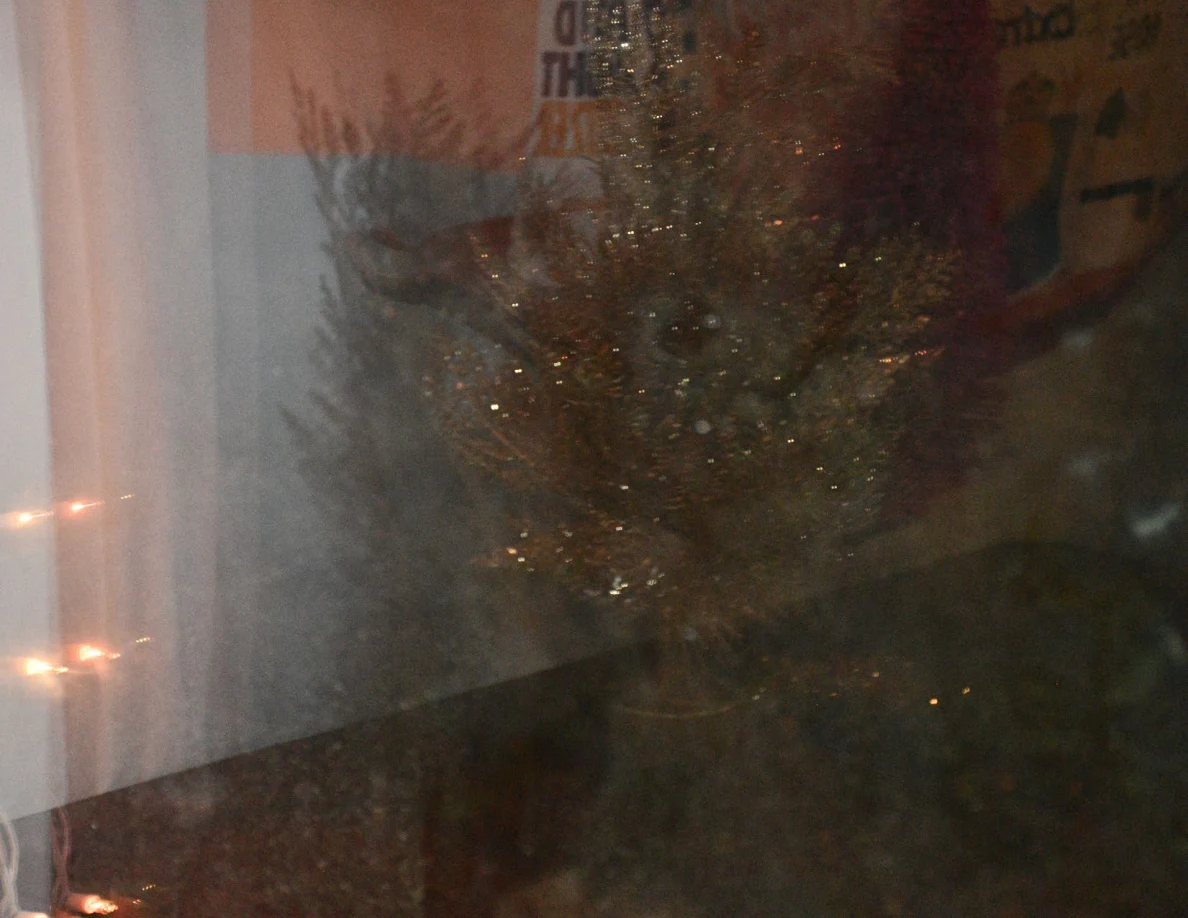 Window glass with smears and reflected decorative objects.