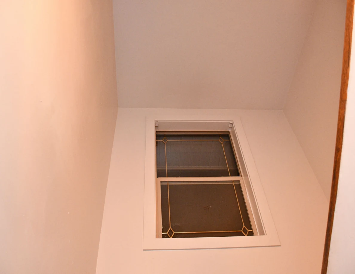Upper stairwell window and surrounding walls.