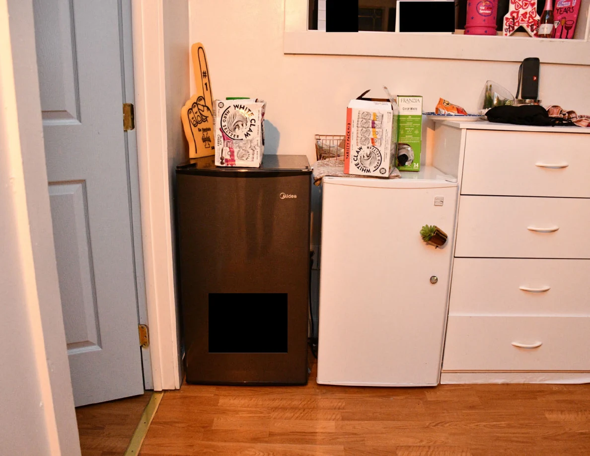 Two compact refrigerators beside a tall white chest of drawers.