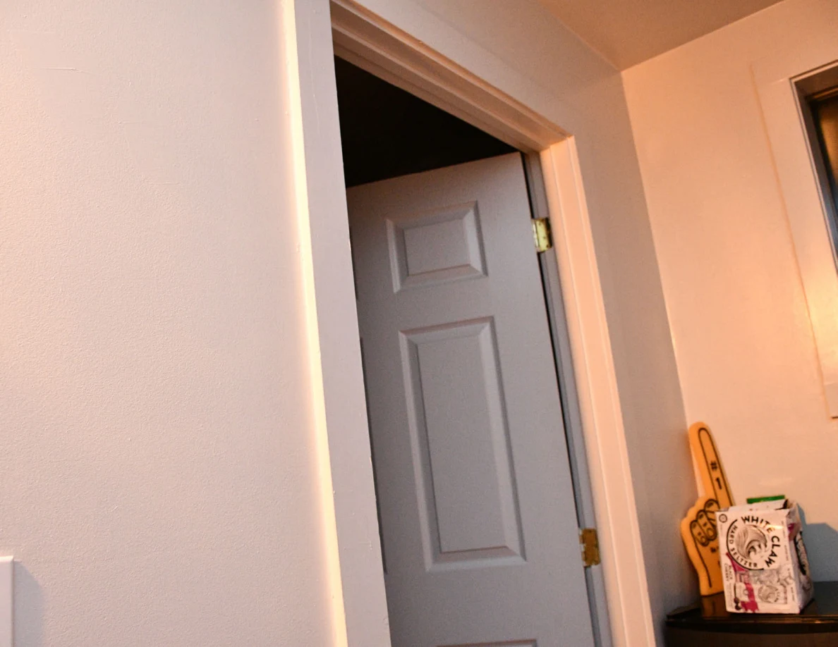 Upper doorway beside a compact refrigerator and decorative items.