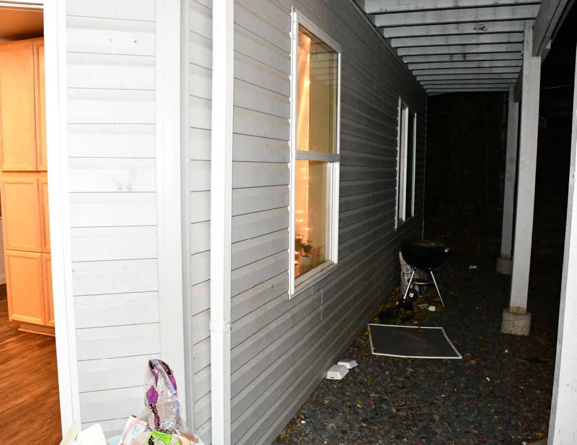 Exterior windows and kettle barbecue grill beneath the balcony.