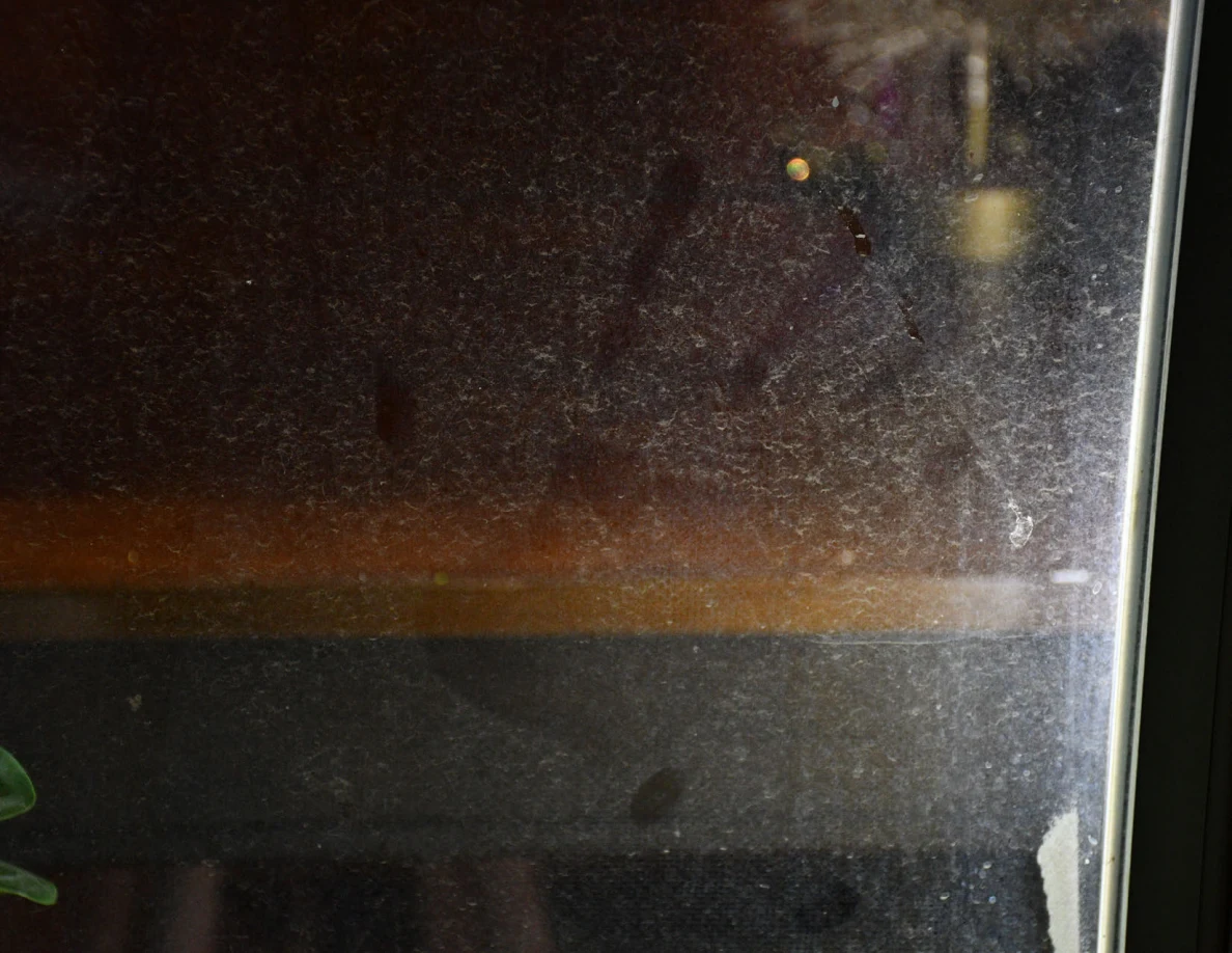 Close view of marks on glass with a tabletop visible behind.