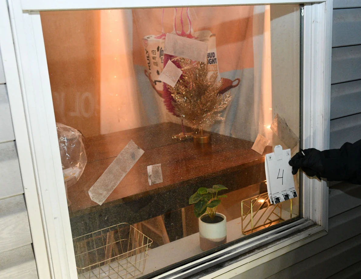 Gloved hand holding reference card 4 beside strips on window glass.