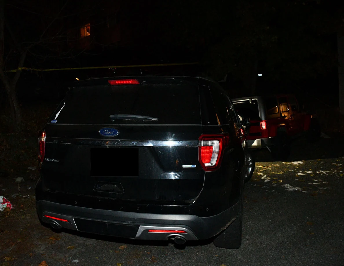 Rear of a black SUV with red Jeep behind.