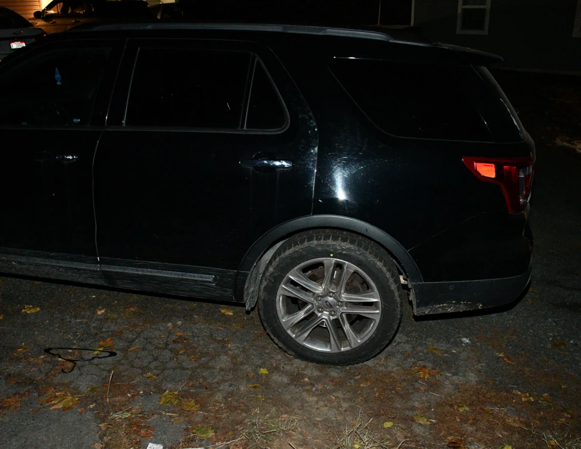 Side and rear wheel of a black SUV.