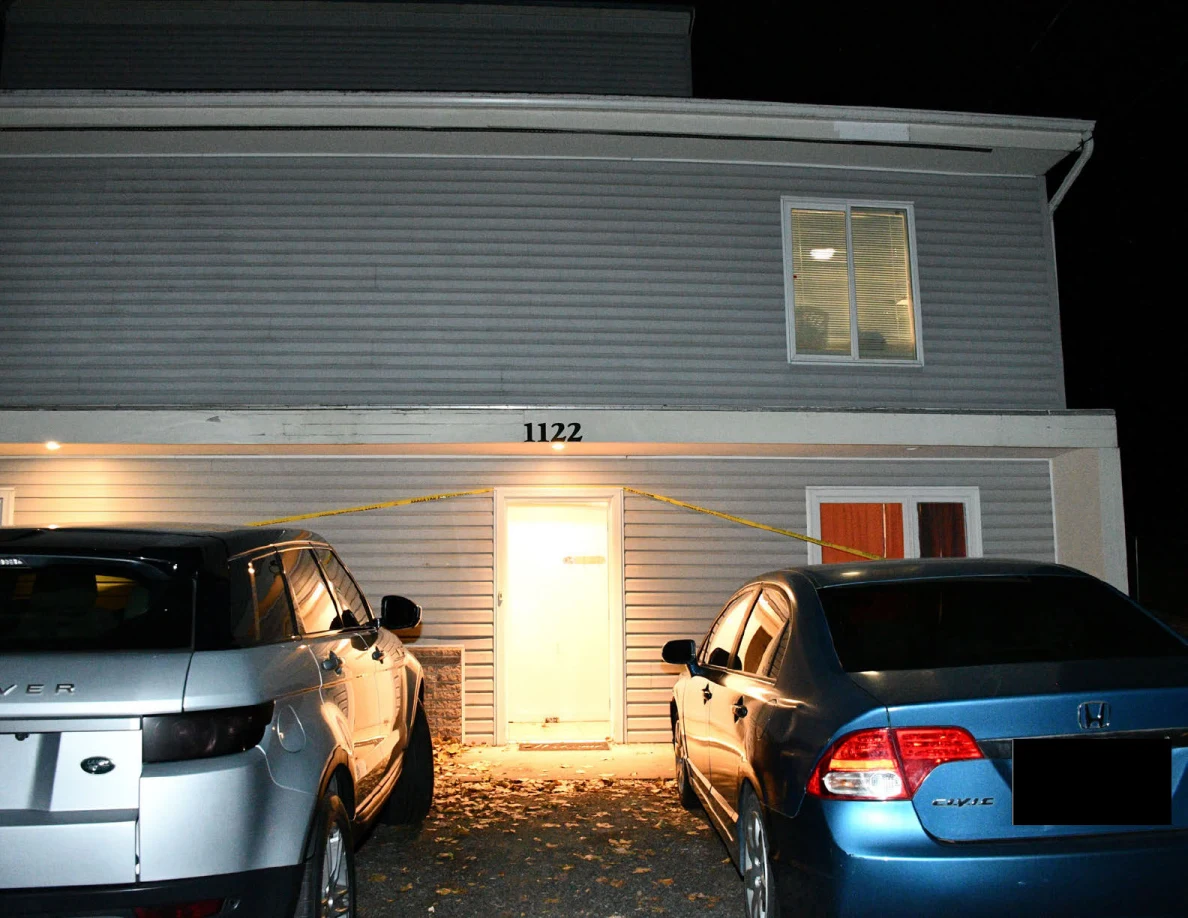 House front, open doorway, silver SUV and blue car.