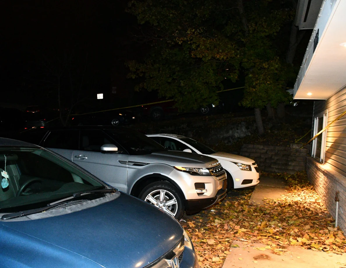 Parked blue car, silver SUV and white car beside illuminated house.