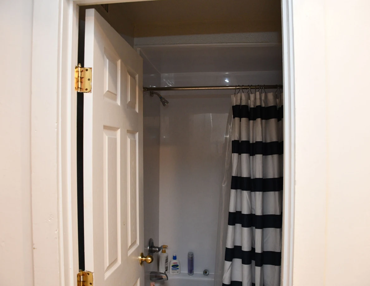 Upper bathroom doorway and striped shower curtain.