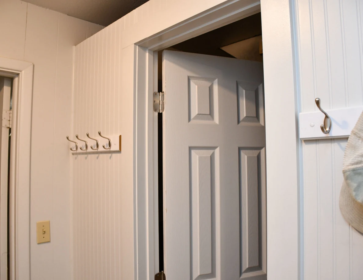 Interior utility-room doorway beside wall hooks.