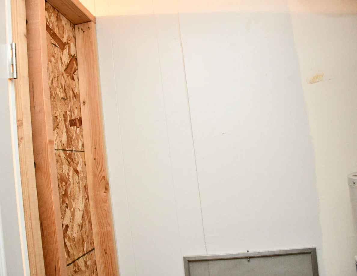 Utility-room wall panels and exposed wooden framing.