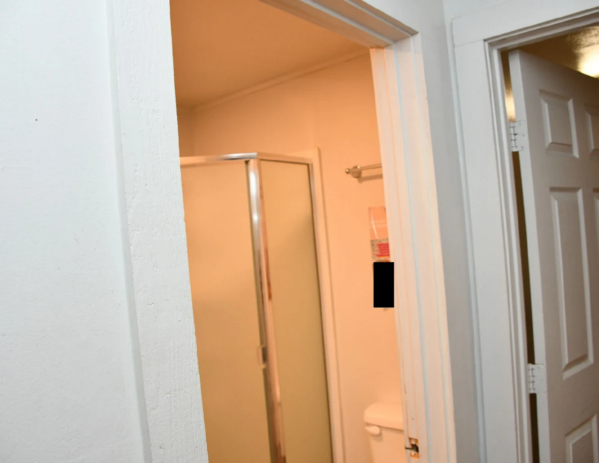 Upper bathroom doorway and glass shower enclosure.