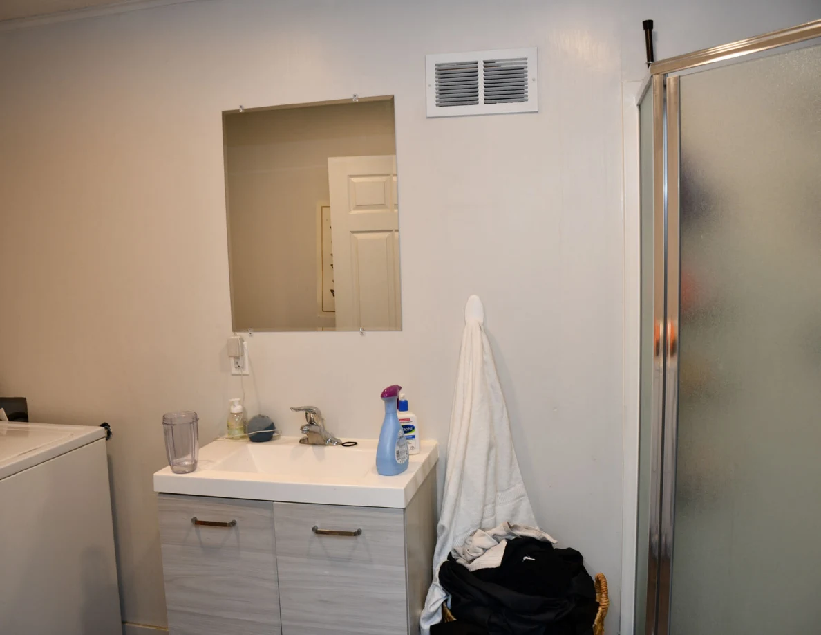 Bathroom vanity, wall mirror and glass shower enclosure.